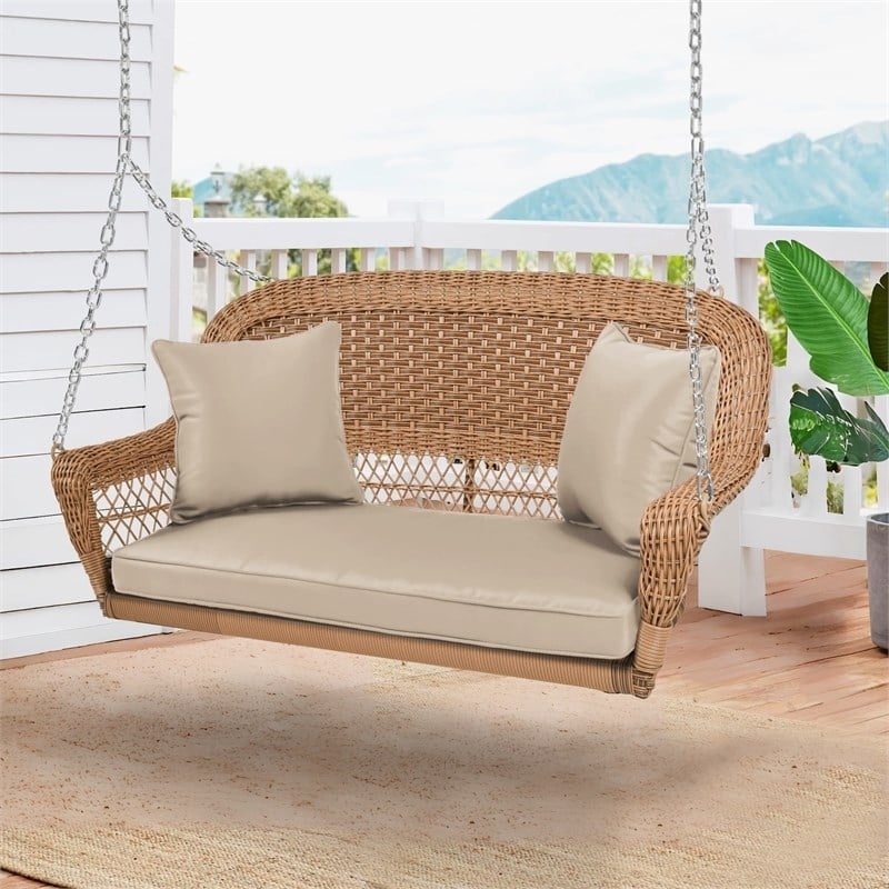 Pemberly Row Resin Wicker Hanging Porch Swing with Cushion in Honey/Tan