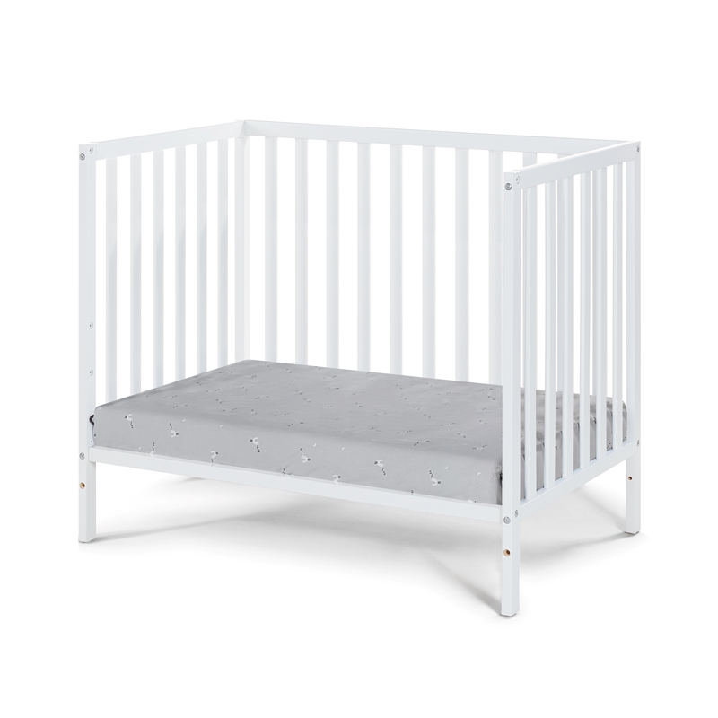 Pemberly Row Contemporary Wood Mini Crib with Mattress Pad in White