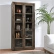 Kosas Home Bradley Tall Oak Wood Cabinet with Glass Doors- Brown Finish